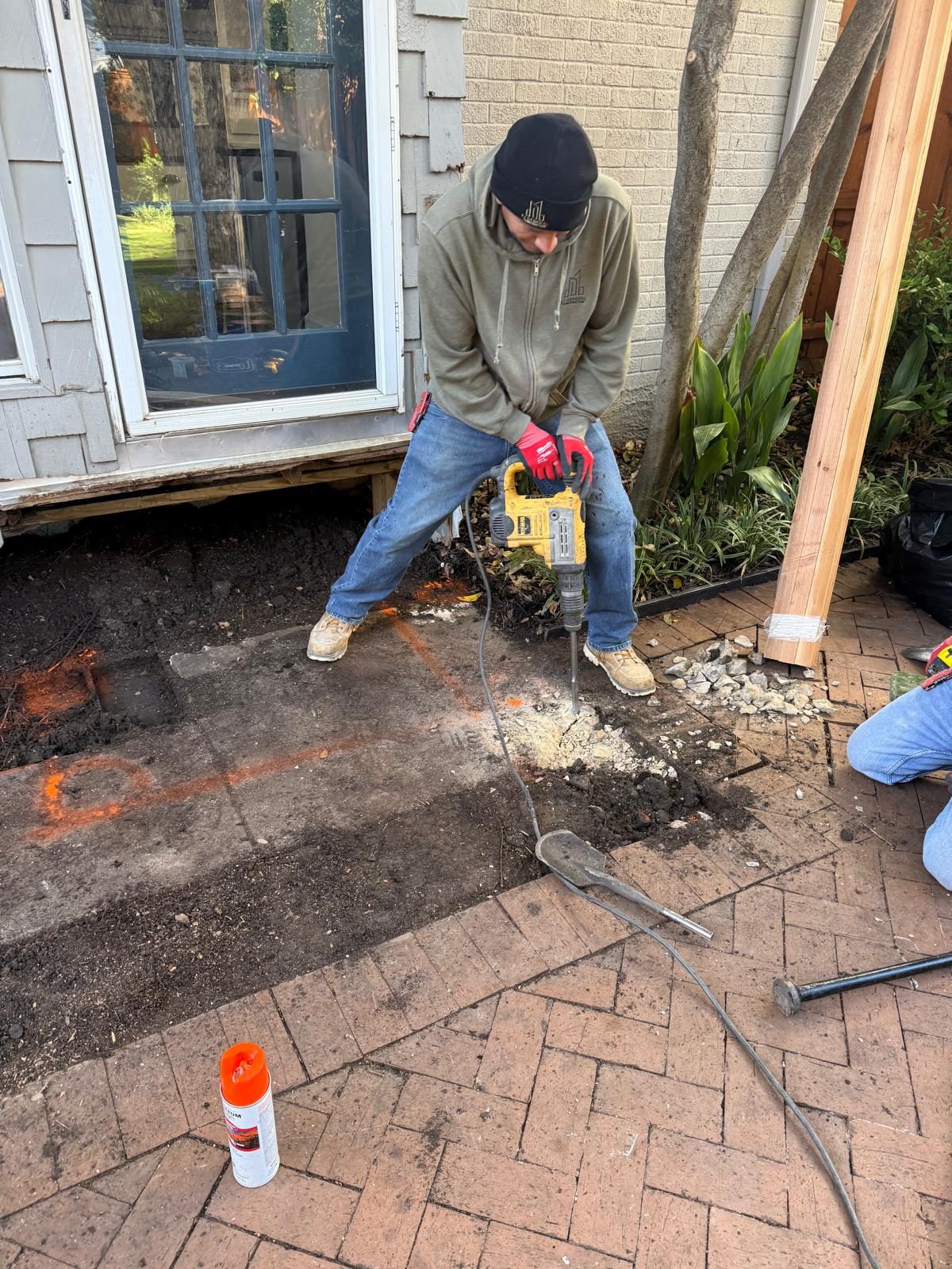 A crew member breaking up an old patio slab during demolition