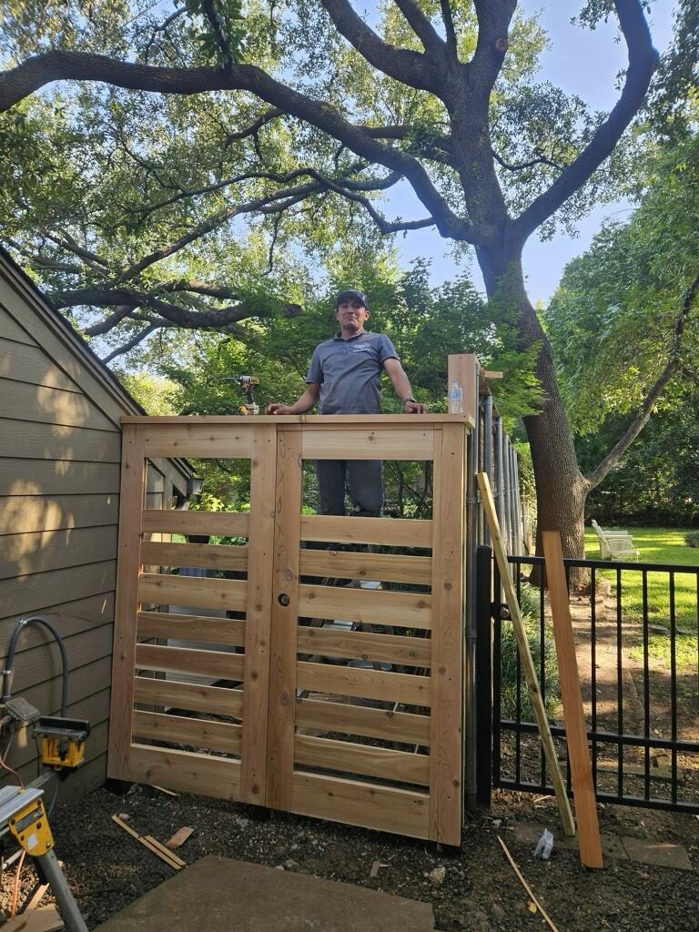 An EJ crew member standing on a half-built custom cedar gate enclosure