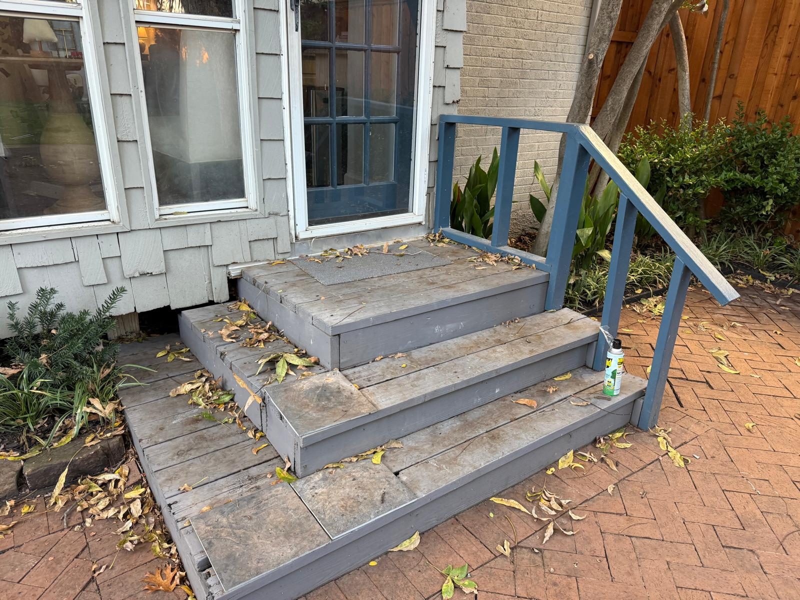 The old, worn gray entry steps before replacement