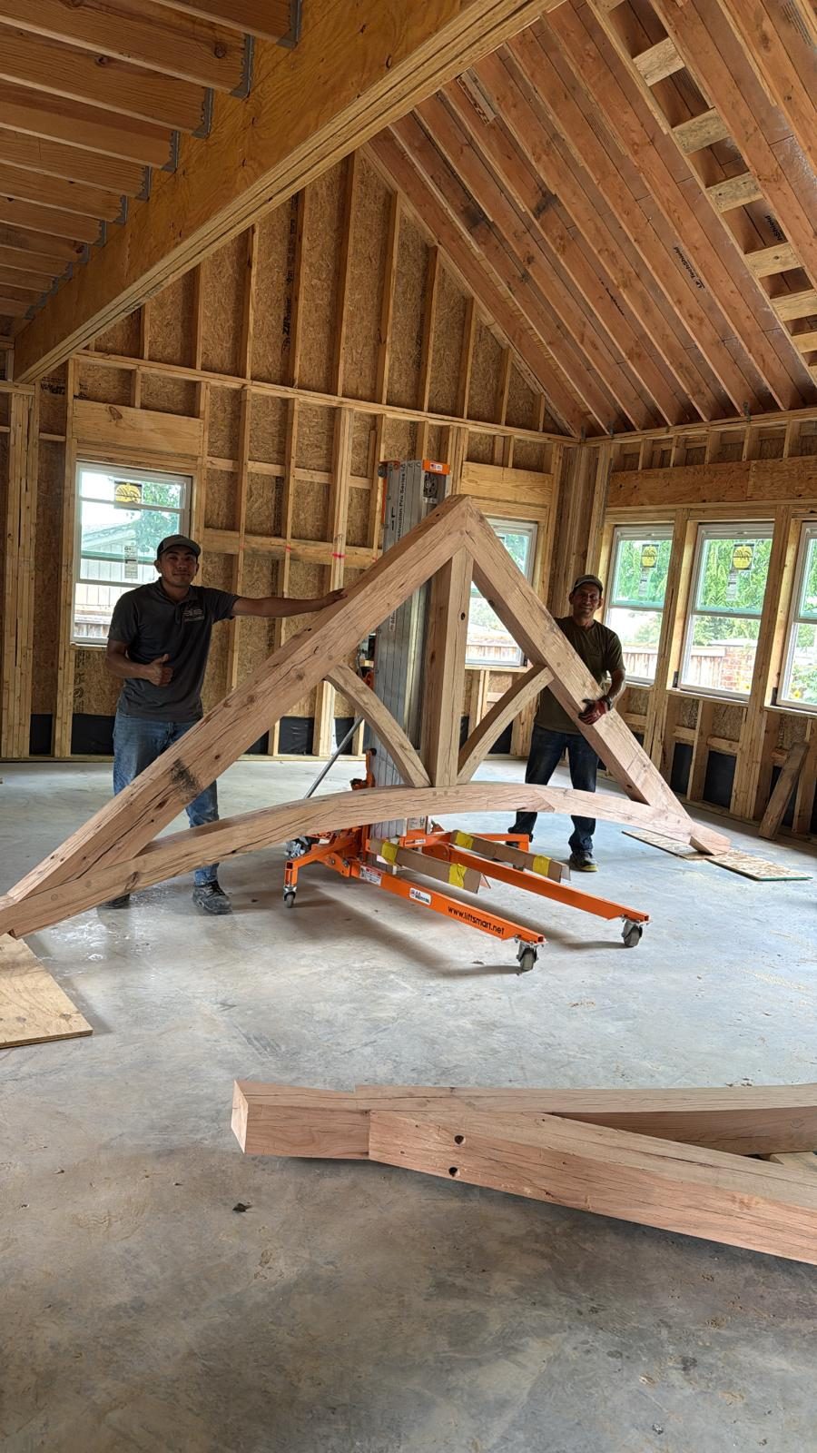 Two EJ crew members assembling a curved timber truss on site